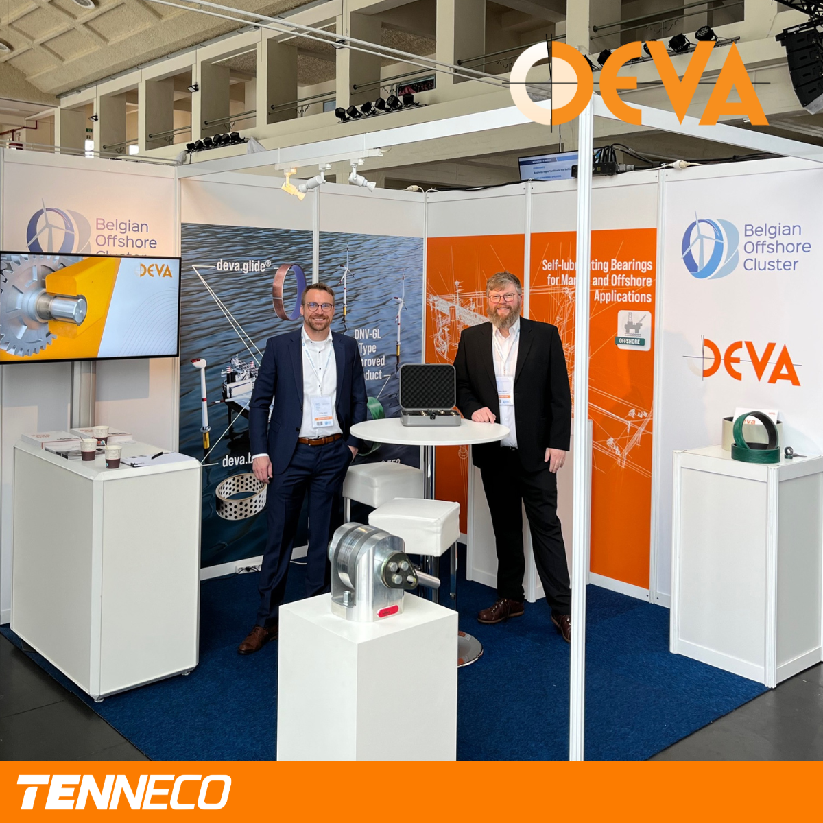 Zwei DEVA-Mitarbeiter am Messestand vor Produktauslage
