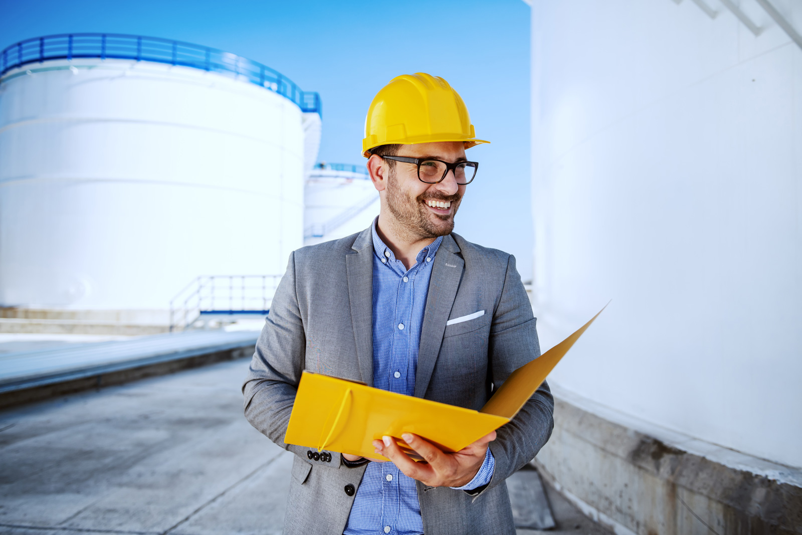 Lachender Ingenieur mit gelbem Ordner 